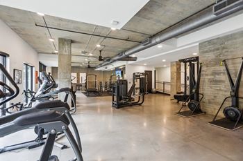 A gym with a variety of equipment including treadmills, weights, and exercise machines.